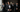 groom and groomsmen wearing custom tuxedos standing confidently in natural light