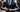 Man in a tailored navy suit with subtle armor elements representing confidence and modern style