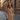 Woman wearing a tailored camel coat walking confidently down an urban street