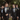 Groomsmen wearing black tuxedos with satin lapels and boutonnieres at an outdoor wedding